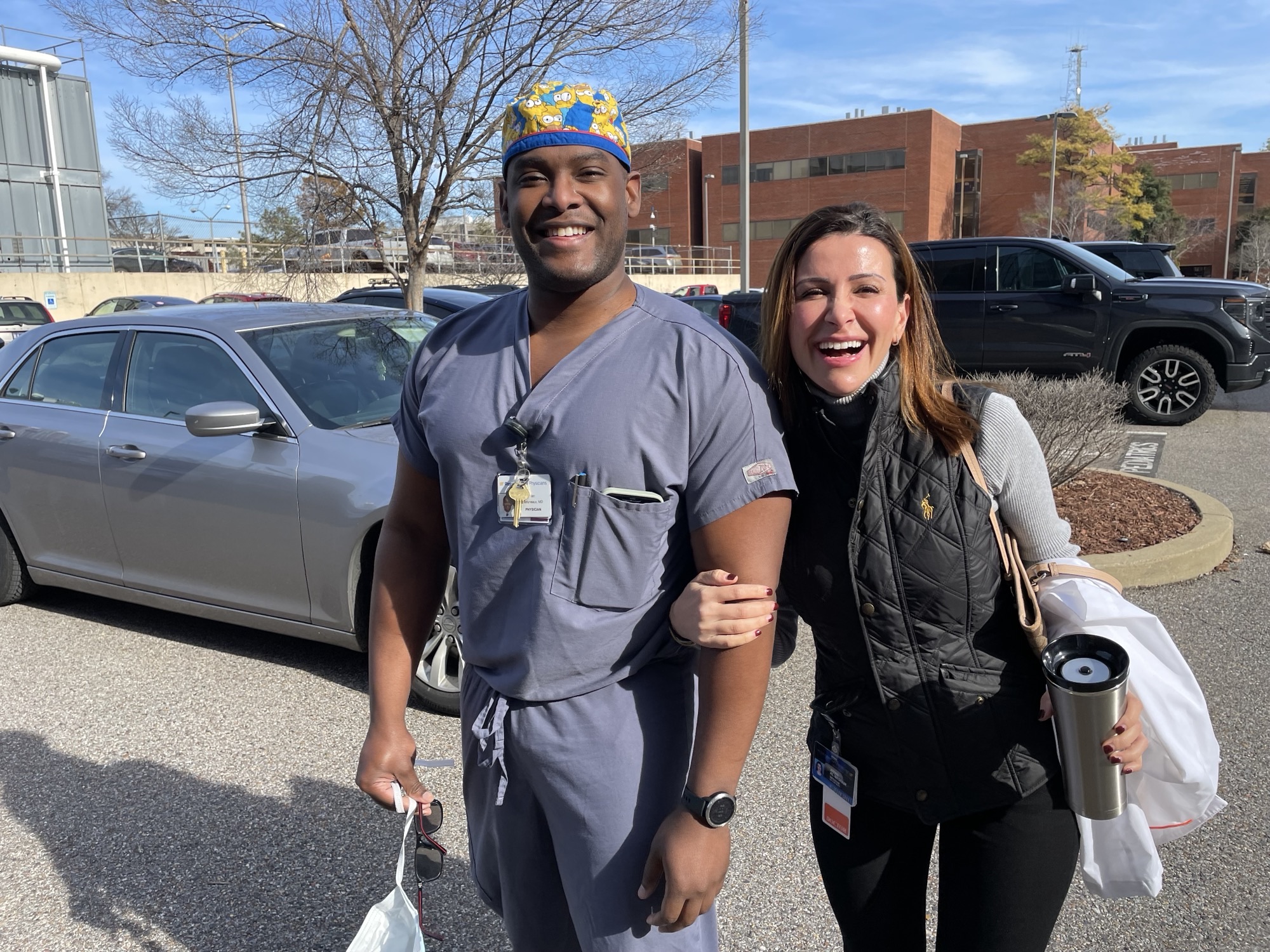 Two fellows smiling coming in from the parking lot