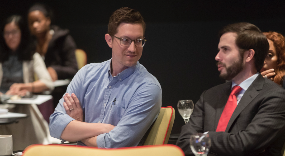 Two male attendees speaking during the conference