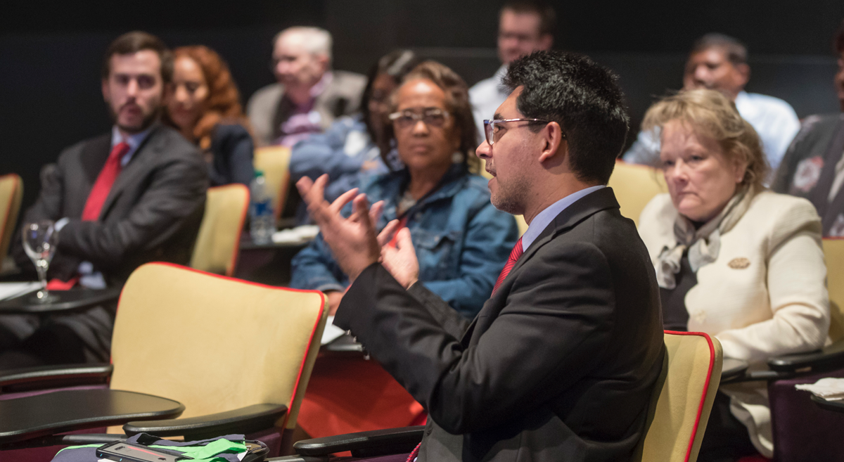 Attendee of the conference speaking while the audience is listening