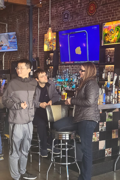 Residents mingling and talking at a bar indoors
