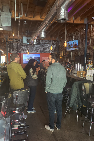 Residents talking at the bar of the pinball venue