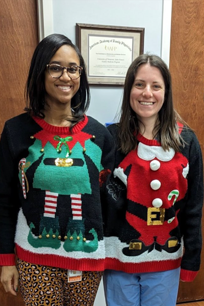 Two female residents in ugly holiday sweaters
