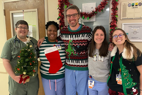 Residents in the hospital hallway in holiday attire