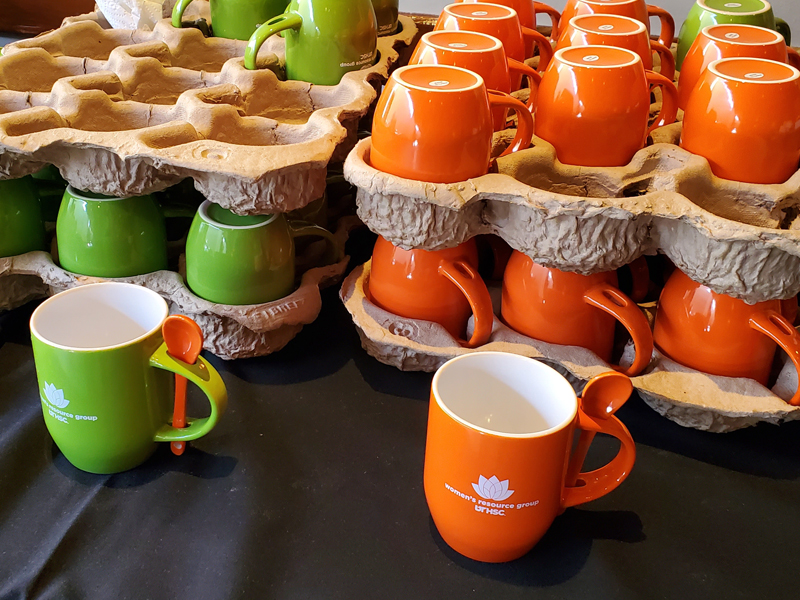 hot cocoa event mugs that are orange and green
