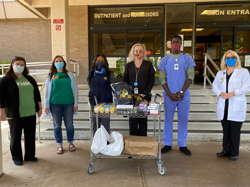 health care heroes stand outside hospital with food donation